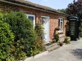 Pam at doorway of cottage - click to enlarge